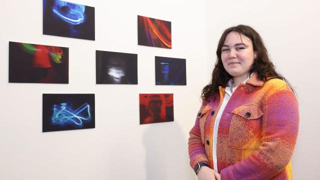 Natasha, a Young Leader from Our Lives Our Voices youth programme, standing in front of her photography project, 
