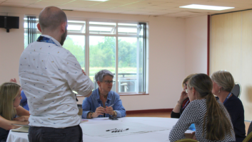 Group of people at a table brainstorming ideas.