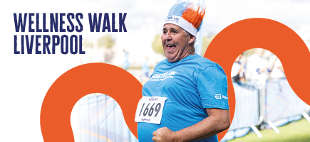 Man walking towards the finish line at a Wellness Walk