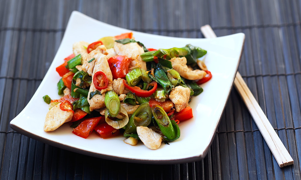Plate of Thai Chicken Stir Fry with some chopsticks next to it.