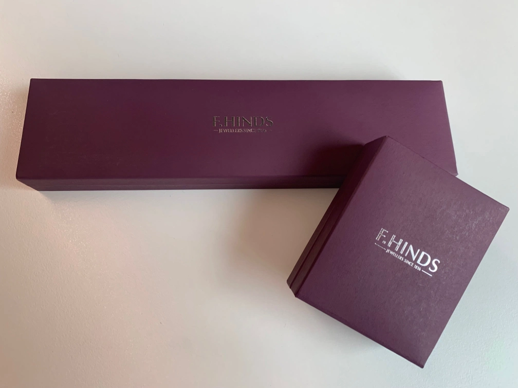 Two closed red boxes of F.Hinds jewellery. 