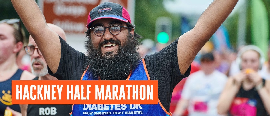 One man has hands in the air with Diabetes UK vest on and  a cap.