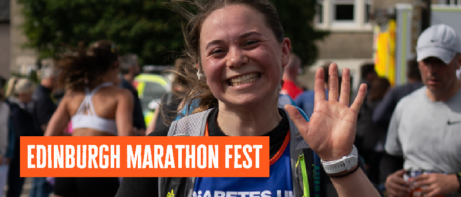 Female runner waving at camera in Diabetes UK Vest