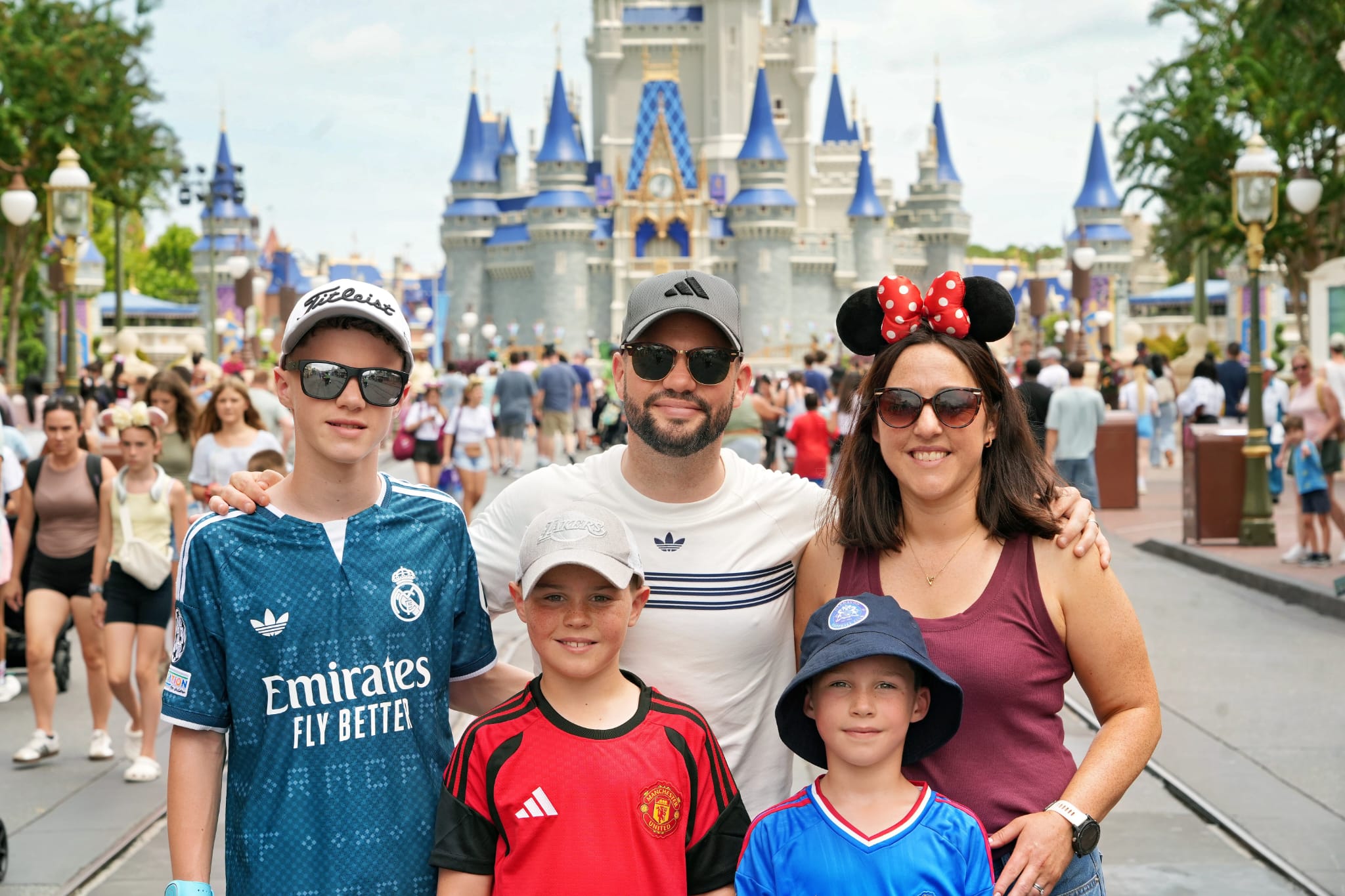 Clare with her husband and three boys on a family holiday, pictured in front of Disneyland Castle.