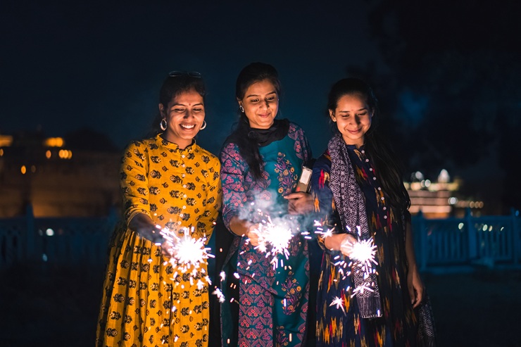 Three women with lights in the dark