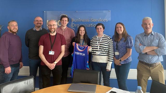 Elaine and colleagues holding Diabetes UK running shirt 