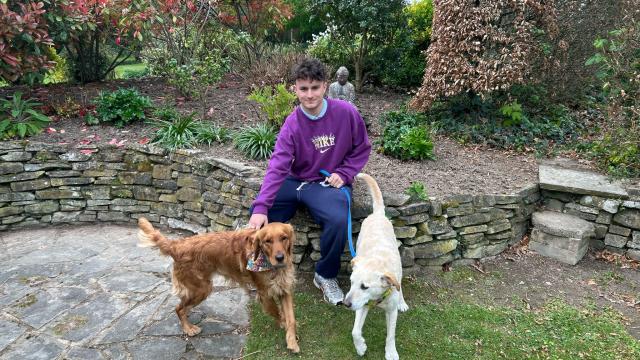 A young man pictured with two dogs 