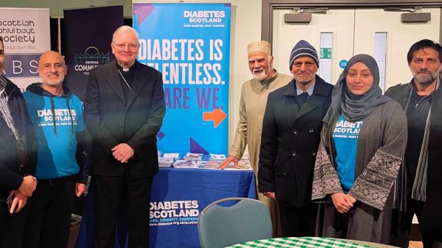 Photo showing a group of people, 2 of whom volunteer as Community Champions with Diabetes UK.