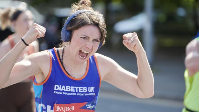Female Runner cheering to crowd with fists raised.