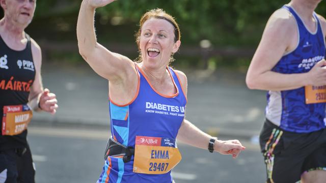 Female runner waving to the crowd