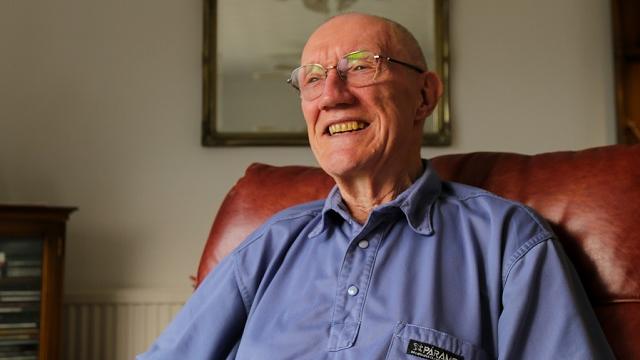 older man sitting smiling at camera