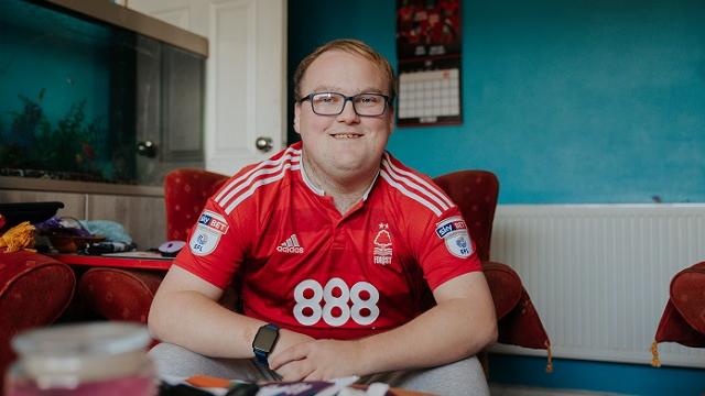 young man sitting smiling at camera
