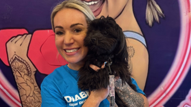 Supporter wearing blue Diabetes UK top and holding a dog
