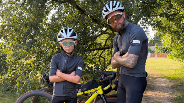 Two cyclists by a tree