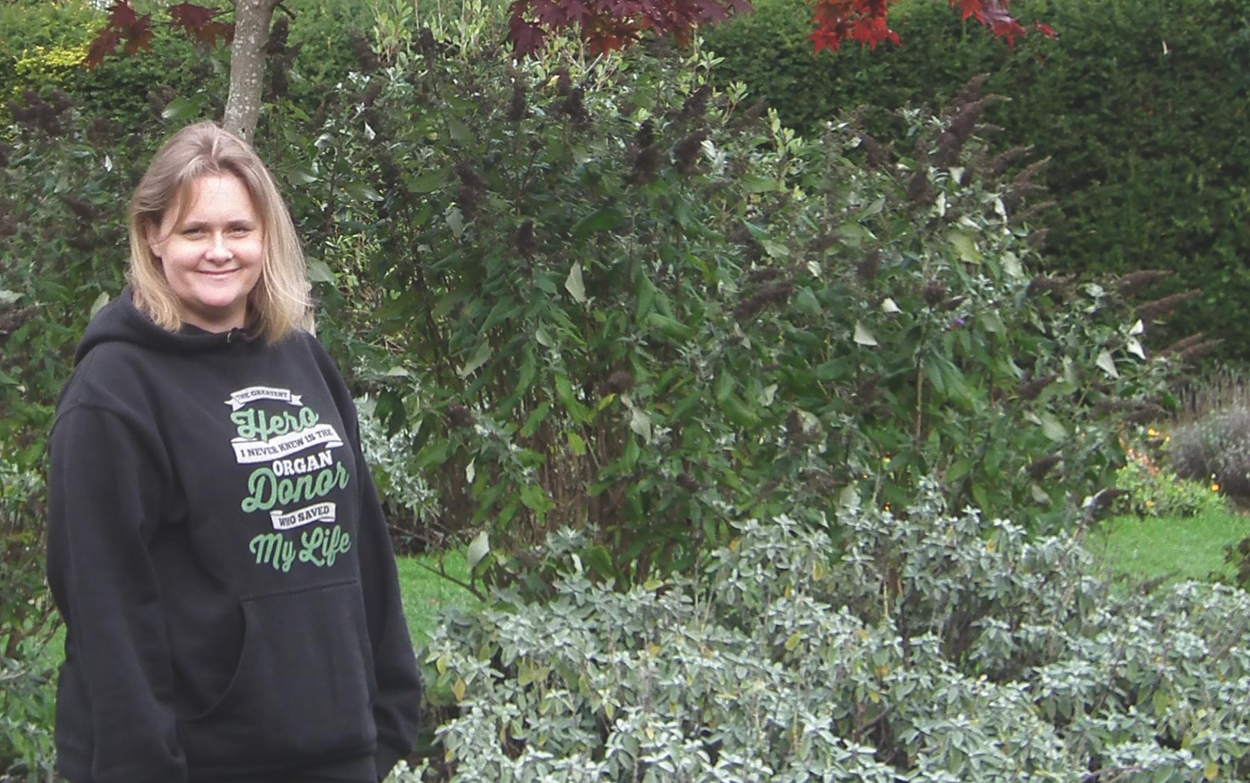 Amanda stands in a garden smiling