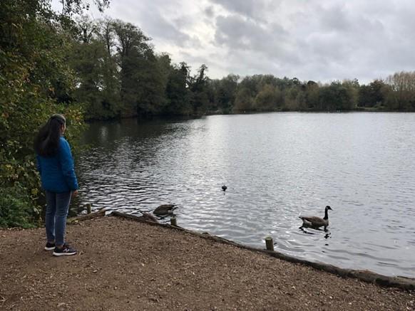 Meera stands looking out at a lake