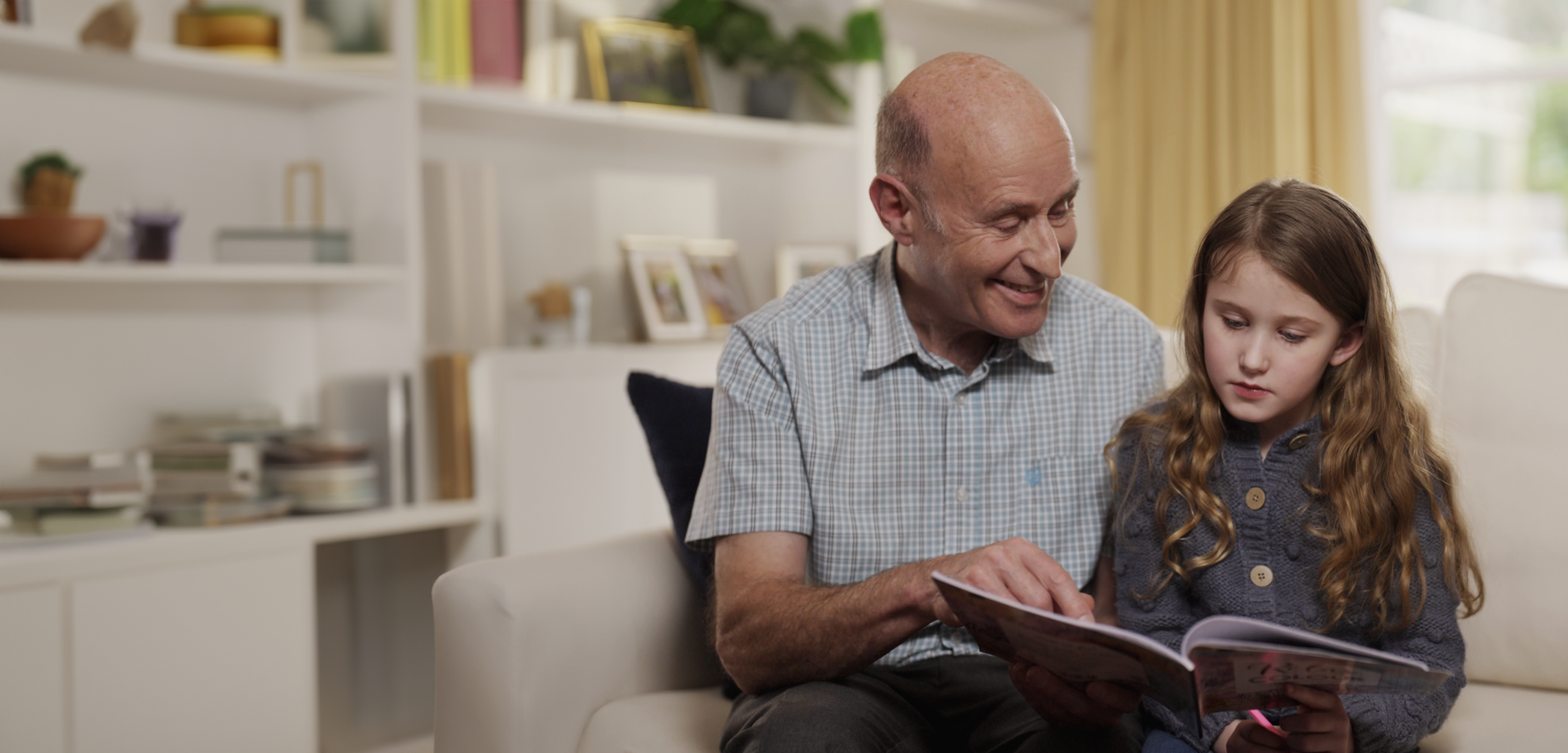 a grandfather reads to his grandaughter