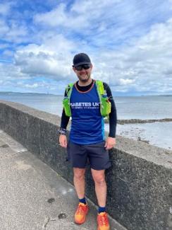 Adrian pictured standing with his Diabetes UK running vest