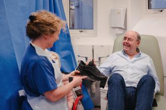 Healthcare professional explaining shoe fitting to man living with diabetes