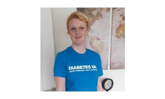 A photo of a blonde woman wearing a blue Diabetes UK t-shirt, smiling to camera