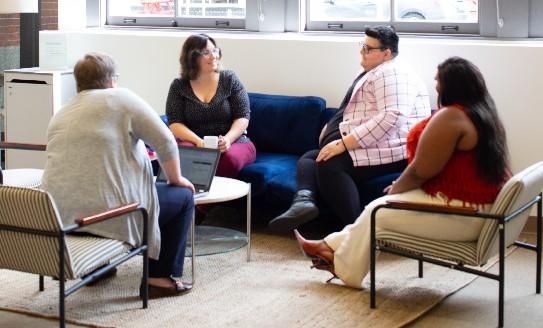 a photo of four people sitting in a circle at a support group