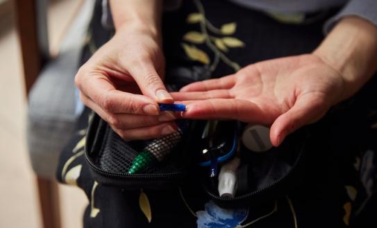 Woman pricking her finger to check blood sugar levels