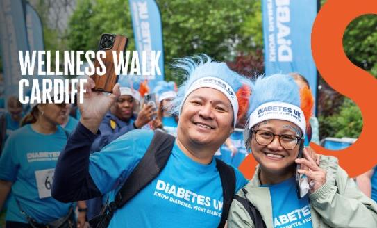 The image shows two people wearing blue t-shirts. There is text that reads 'Wellness Walk Cardiff'.