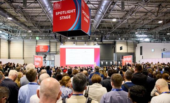 A crowd of researchers gathered around a speaker at EASD