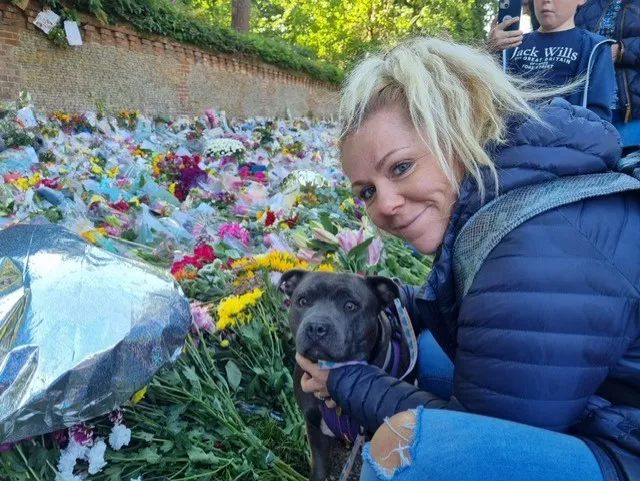 lady looking at flowers with her dog