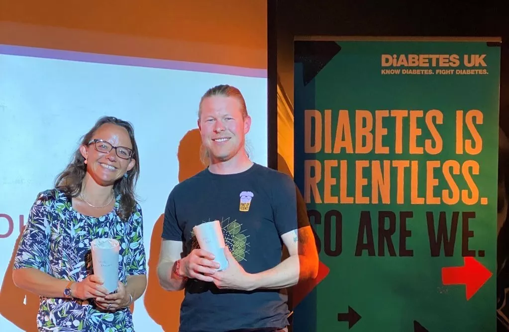 Dr Chloe Rackham and Dr Craig Beall receiving a pint glass each