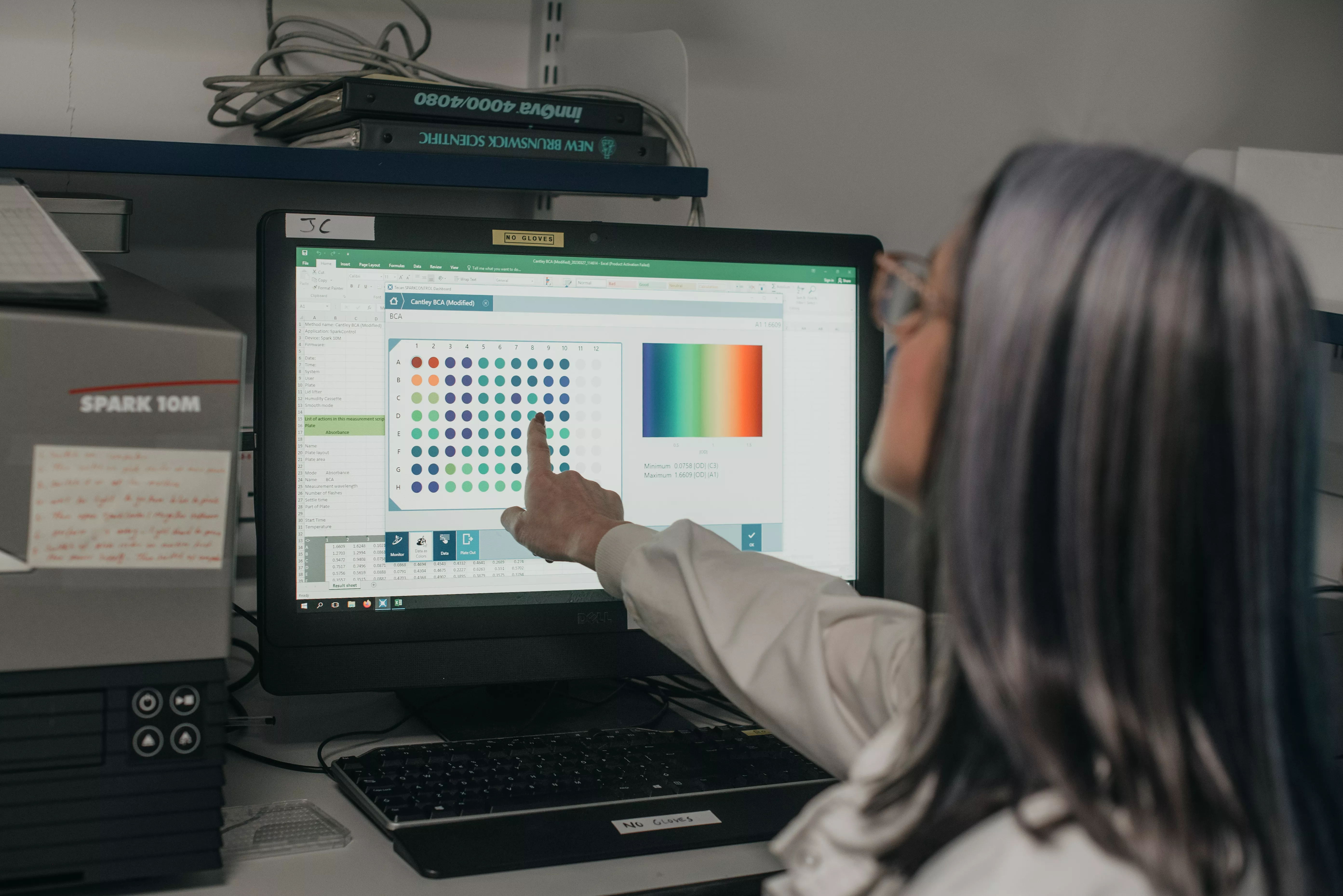 A scientist points at a computer screen