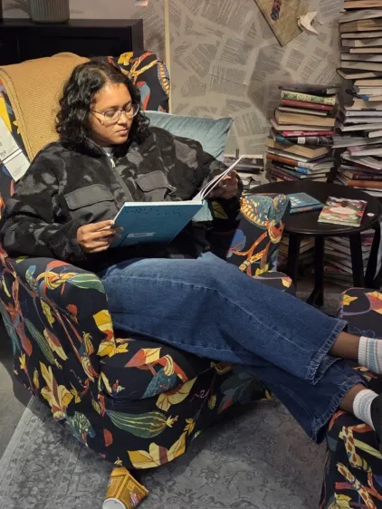 Abeeda sat in chair reading