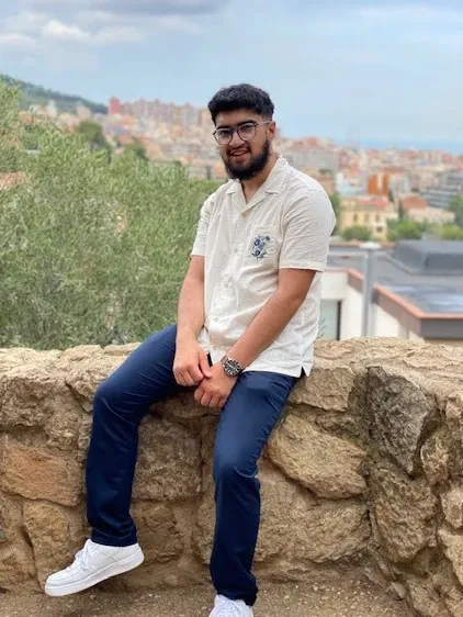 Hamza sitting on a wall