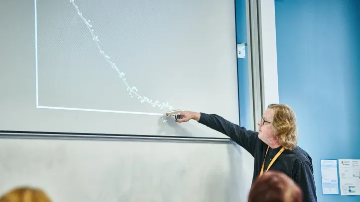 Man talking through graph on screen 