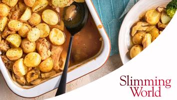 A white baking dish potatoes, chicken, and mushrooms in a brown sauce