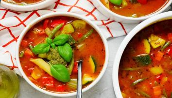 Bowl of minestrone soup on a red and white tea towel