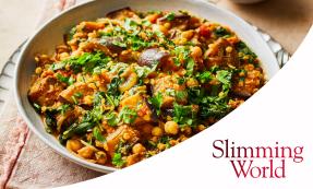 A white bowl filled with aubergine and lentil curry, topped with fresh coriander