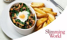 Small white oval baking dish with egg, spinach, and mushrooms on a white plate with chips