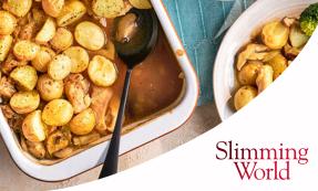 A white baking dish potatoes, chicken, and mushrooms in a brown sauce