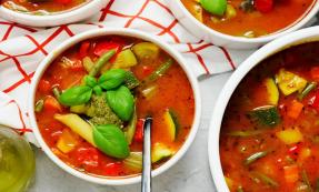 Bowl of minestrone soup on a red and white tea towel